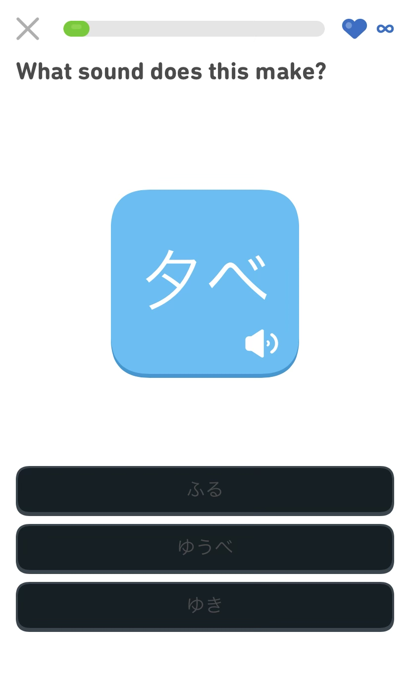 Three buttons displaying options to try and match the phonetic spelling of the word “evening” in Japanese. The button’s background color is black, and their text is a dark gray. At the top of the screen is the prompt, “What sound does this make?” Screenshot of the Duolingo app.